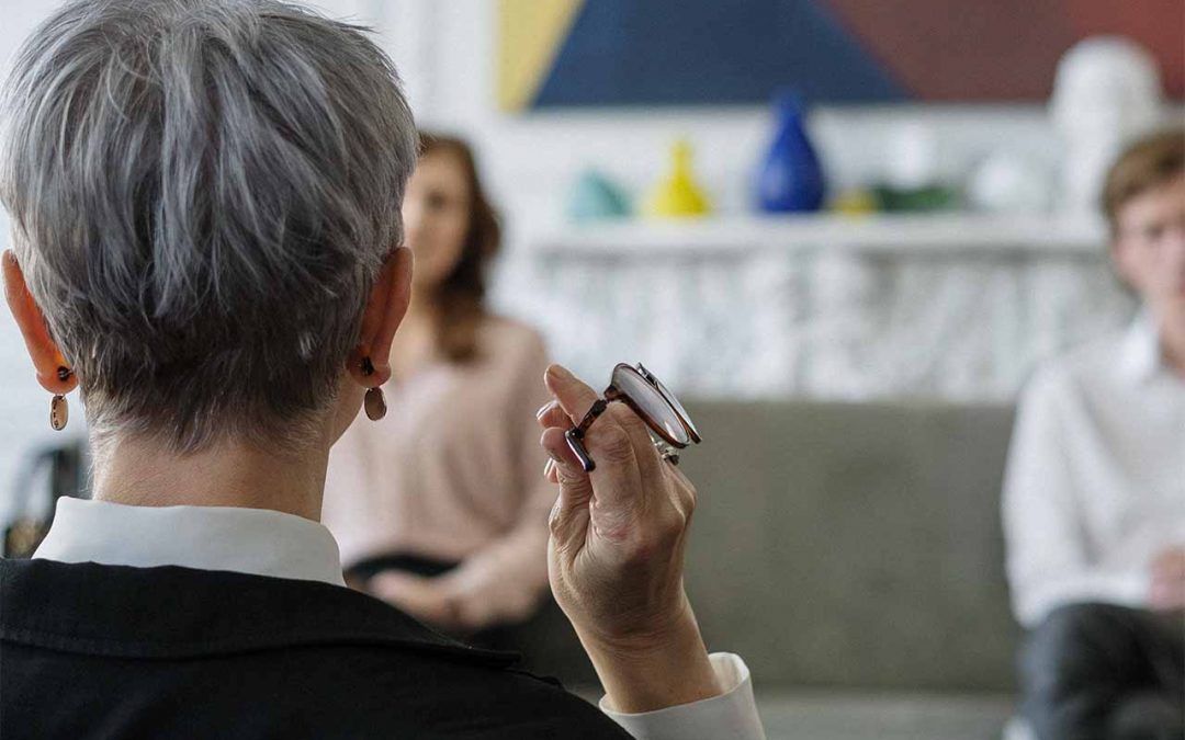 Therapist holding glasses during counseling session