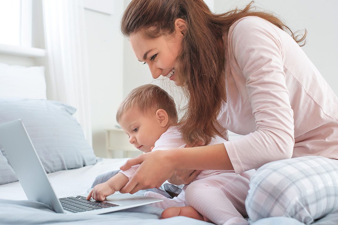 Smiling mom and baby at computer